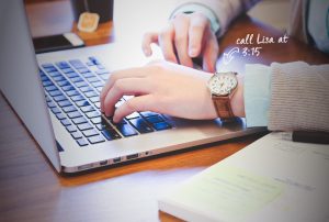 a person wearing a watch is typing on a laptop