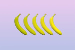 five bananas are lined up in a row on a purple background