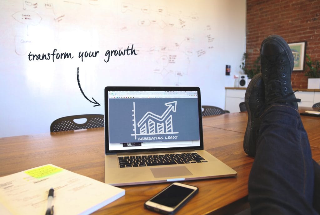 a person's feet rest on a table with a laptop with the words transform your growth