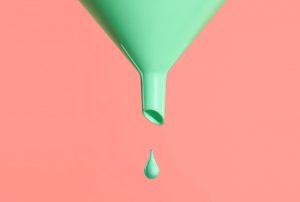 a green funnel with a drop of liquid coming out of it