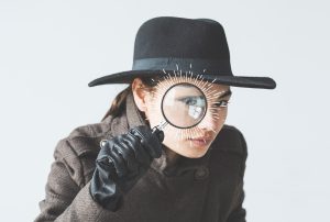a person in a hat is looking through a magnifying glass