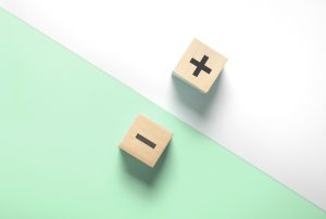 two wooden blocks with a plus and minus sign on them
