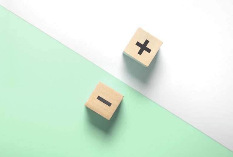 two wooden blocks with a plus and minus sign on them