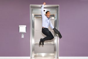 a man is jumping in the air while holding a briefcase in front of an elevator