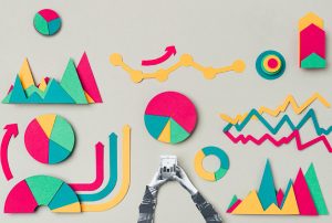 a person holding a cell phone surrounded by colorful paper graphs