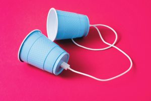 two blue cups with wires attached to them on a pink background