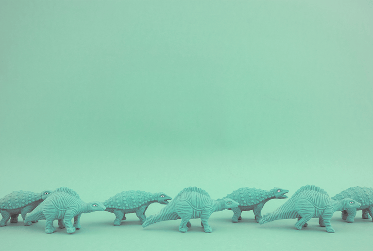 a row of toy dinosaurs on a green background