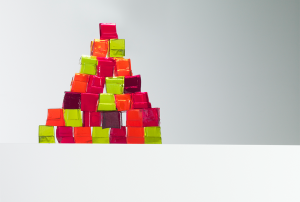 a pyramid of brightly colored blocks on a white surface