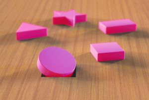 pink geometric shapes on a wooden surface with a circle stuck in a square hole