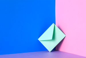 a green envelope is leaning against a blue and pink wall