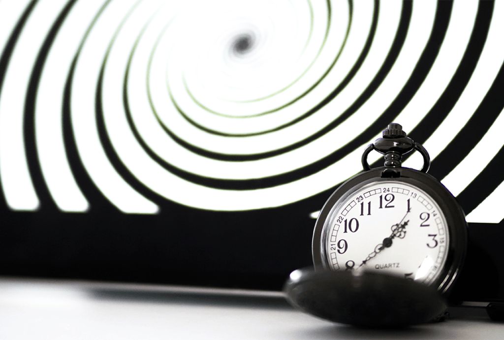 a pocket watch is sitting in front of an optical illusion