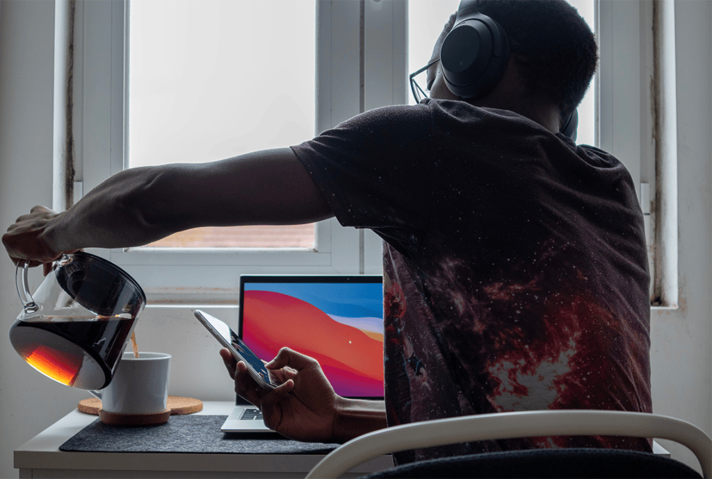 a man wearing headphones pours coffee into a cup