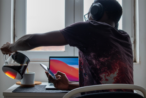 a man wearing headphones pours coffee into a cup