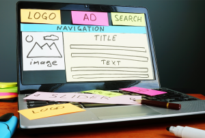A laptop with sticky notes on it that say logo, ad, search, and navigation.