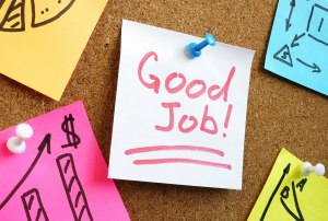 a post it note that says good job is pinned to a cork board