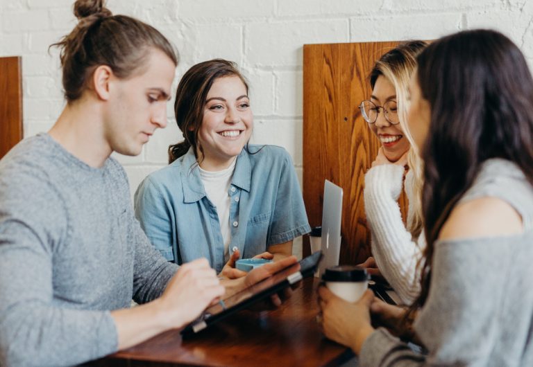 Salespeople at a table being social over coffee.