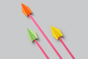 three paper planes are flying in in one direction