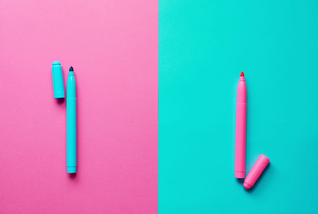 a blue and a pink marker on a pink and blue background