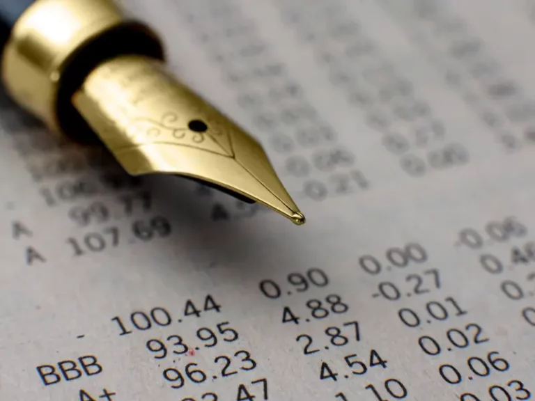 a fountain pen is sitting on top of a piece of paper with numbers on it