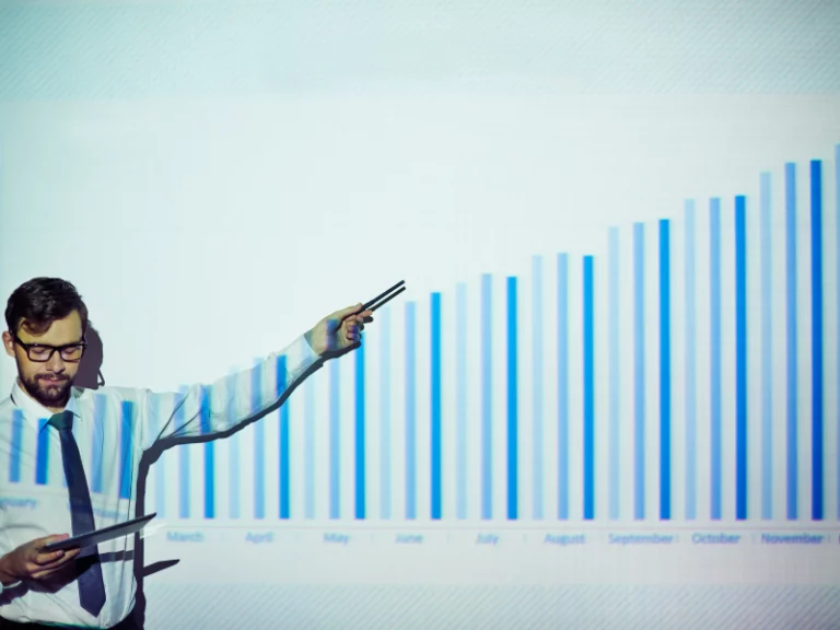 a man is giving a presentation with a graph showing a growth from march to November