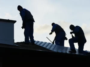 three people are working on the roof of a building