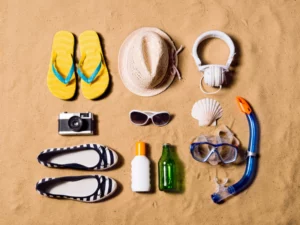 multiple beach accessories are laid out on a sandy beach