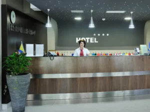 a woman stands at a hotel reception desk