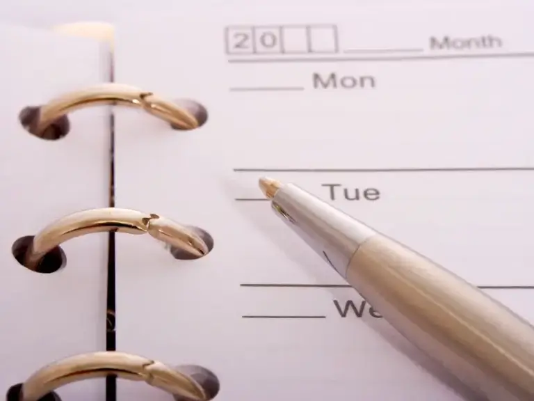 a pen is pointing at a calendar that says mon and tue