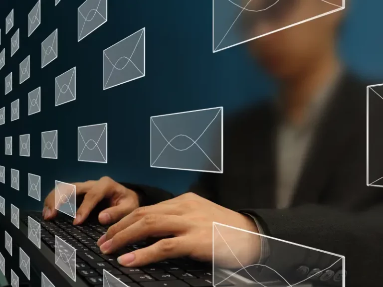 a person typing on a keyboard with envelopes coming out of the screen
