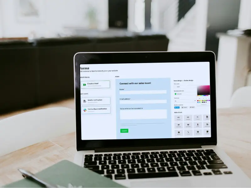 en bærbar computer er åben for en hjemmeside på et bord.