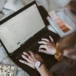 Woman typing on a laptop to send an email