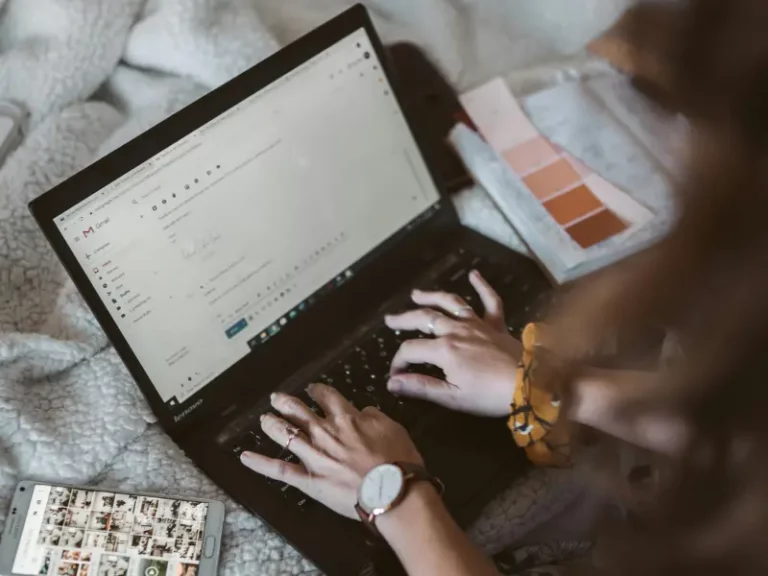 Woman typing on a laptop to send an email