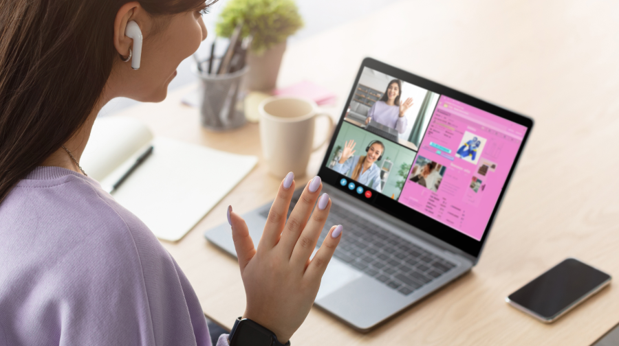 uma senhora numa videochamada a acenar para a câmara